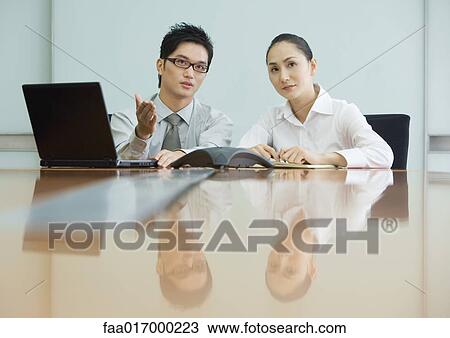 Stock Image - Business executives working in conference room. Fotosearch
