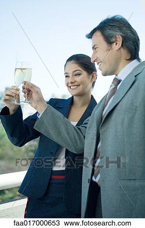 Stock Image - Business partners clinking glasses of champagne. Fotosearch