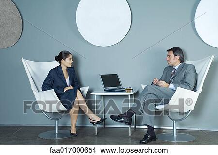 Businessman and businesswoman sitting face to face, having discussion View Large Photo Image Picture - Businessman and businesswoman sitting face to face, having discussion. Fotosearch