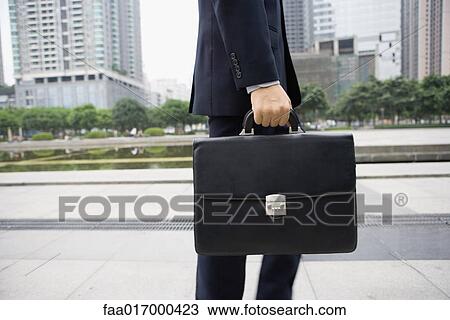 Businessman carrying briefcase, mid section View Large Photo Image Stock Image - Businessman carrying briefcase, mid section. Fotosearch