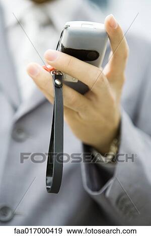Stock Photo - Businessman holding cell phone in hand, close-up. Fotosearch