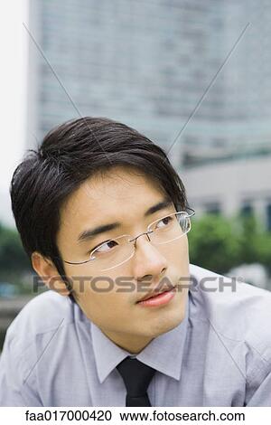 Stock Image - Businessman looking up, portrait. Fotosearch
