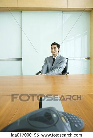 Businessman sitting at conference table View Large Photo Image Stock Photography - Businessman sitting at conference table. Fotosearch