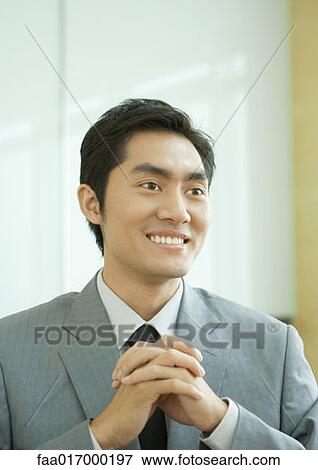 Businessman smiling with clasped hands, portrait View Large Photo Image Stock Photo - Businessman smiling with clasped hands, portrait. Fotosearch