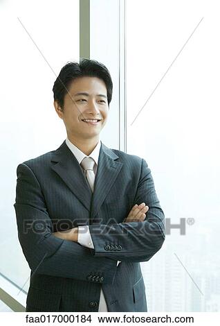 Businessman standing with arms folded, smiling View Large Photo Image Picture - Businessman standing with arms folded, smiling. Fotosearch