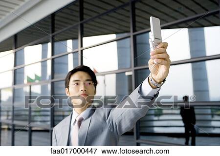 Businessman taking photo with cell phone View Large Photo Image Stock Photo - Businessman taking photo with cell phone. Fotosearch