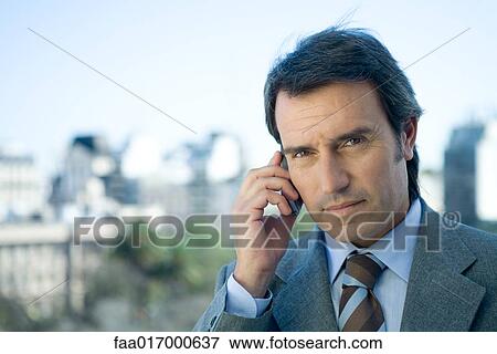 Businessman using cell phone, skyline in background View Large Photo Image Stock Photo - Businessman using cell phone, skyline in background. Fotosearch