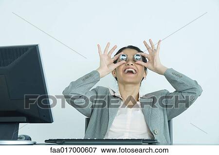 Businesswoman holding yinyang balls in front of eyes, laughing View Large Photo Image Stock Photo - Businesswoman holding yinyang balls in front of eyes, laughing. Fotosearch