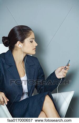 Stock Photo - Businesswoman listening to MP3 player. Fotosearch