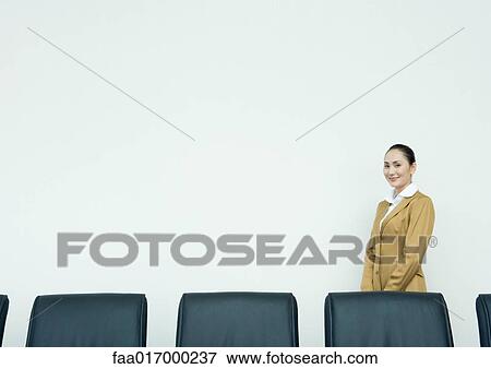 Businesswoman standing in conference room View Large Photo Image Stock Photo - Businesswoman standing in conference room. Fotosearch