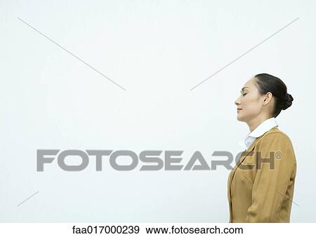 Businesswoman standing with eyes shut, side view View Large Photo Image Stock Photo - Businesswoman standing with eyes shut, side view. Fotosearch