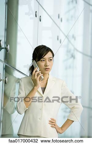 Businesswoman using cell phone, hand on hip View Large Photo Image Stock Image - Businesswoman using cell phone, hand on hip. Fotosearch