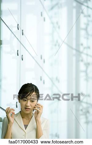 Stock Image - Businesswoman using cell phone. Fotosearch
