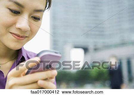 Businesswoman using messaging phone, close-up View Large Photo Image Stock Image - Businesswoman using messaging phone, close-up. Fotosearch