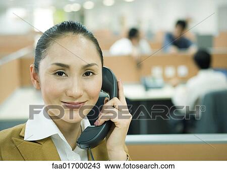 Businesswoman using phone in office View Large Photo Image Stock Image - Businesswoman using phone in office. Fotosearch