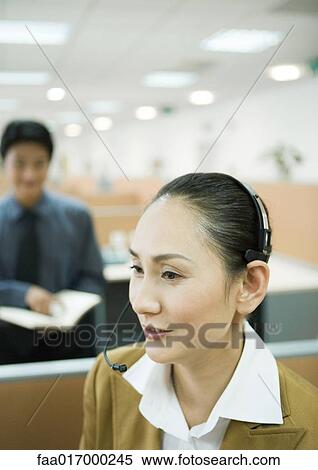 Stock Photography - Businesswoman wearing headset in office. Fotosearch
