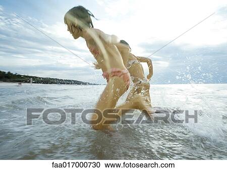 Stock Image - Children racing in shallow water. Fotosearch