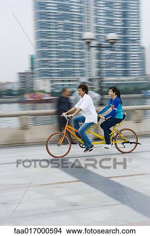 Couple riding tandem bicycle View Large Photo Image Picture - Couple riding tandem bicycle. Fotosearch
