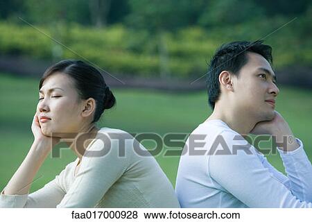 Stock Photo - Couple sitting back to back, resting heads in hands. Fotosearch
