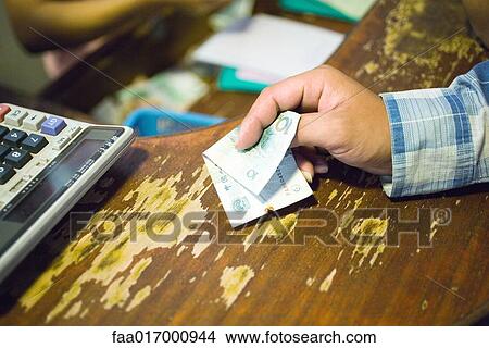 Customer holding out banknote to pay, cropped view View Large Photo Image Picture - Customer holding out banknote to pay, cropped view. Fotosearch