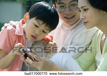 Family looking at digital camera together, close-up View Large Photo Image Stock Image - Family looking at digital camera together, close-up. Fotosearch