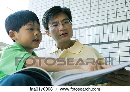 Father and son looking at book together View Large Photo Image Stock Photo - Father and son looking at book together. Fotosearch