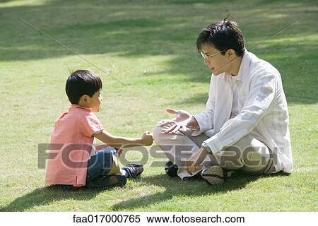Father and son sitting on grass playing "rock paper scissors" View Large Photo Image Stock Photography - Father and son sitting on grass playing "rock paper scissors". Fotosearch