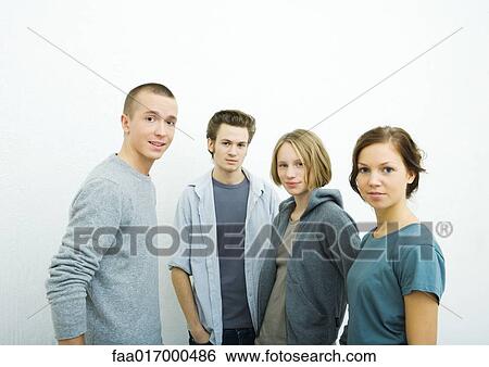 Stock Photograph - Four young friends, looking at camera, portrait. Fotosearch