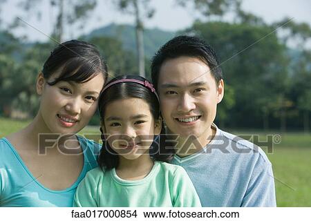 Picture - Girl and parents, smiling at camera, portrait. Fotosearch