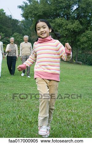 Girl dancing while family watches in background View Large Photo Image Stock Photography - Girl dancing while family watches in background. Fotosearch