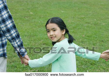 Stock Image - Girl looking over shoulder, smiling at camera. Fotosearch