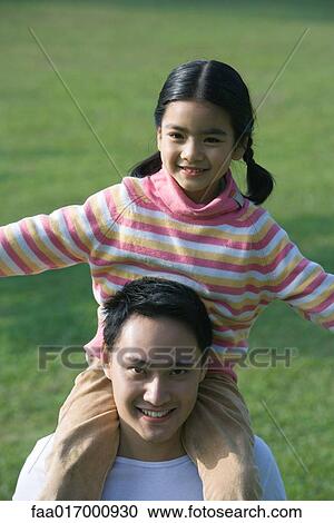 Girl sitting on father's shoulders View Large Photo Image Stock Image - Girl sitting on father's shoulders. Fotosearch
