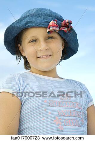 Girl wearing sun hat, smiling at camera, low angle view View Large Photo Image Stock Image - Girl wearing sun hat, smiling at camera, low angle view. Fotosearch