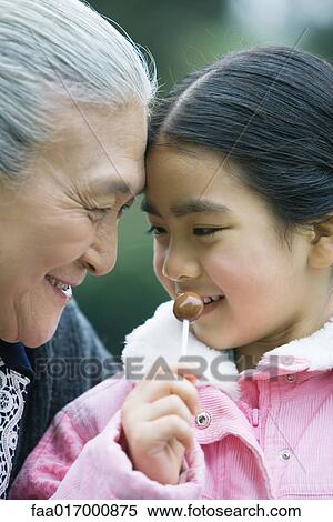 Girl with grandmother, eating lollipop View Large Photo Image Stock Photography - Girl with grandmother, eating lollipop. Fotosearch