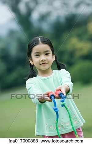 Stock Photo - Little girl holding out jump rope toward camera. Fotosearch