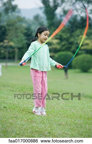Stock Photograph - Little girl playing with jumping rope. Fotosearch