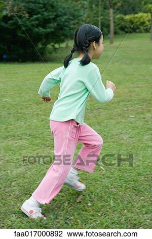Stock Image - Little girl running across grass. Fotosearch