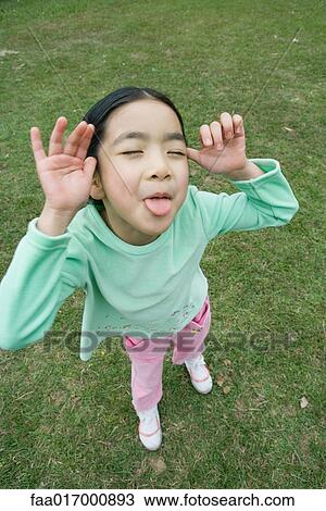 Little girl sticking out tongue at camera View Large Photo Image Stock Image - Little girl sticking out tongue at camera. Fotosearch