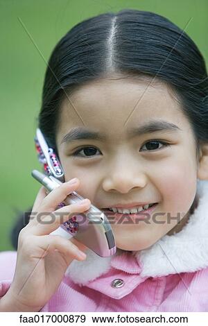 Stock Photo - Little girl using cell phone, close-up. Fotosearch