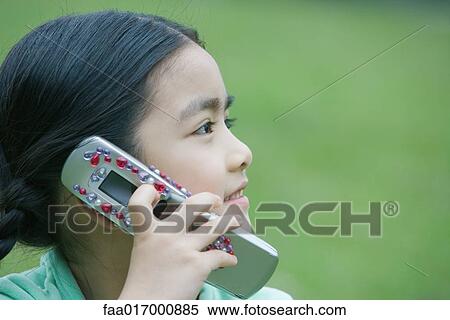 Stock Photography - Little girl using cell phone, close-up. Fotosearch