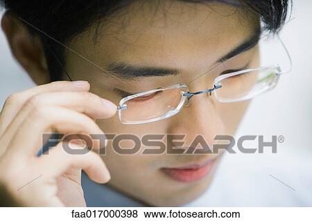 Man adjusting glasses, close-up View Large Photo Image Stock Photo - Man adjusting glasses, close-up. Fotosearch