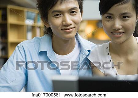 Man and woman using laptop, smiling at camera View Large Photo Image Stock Image - Man and woman using laptop, smiling at camera. Fotosearch