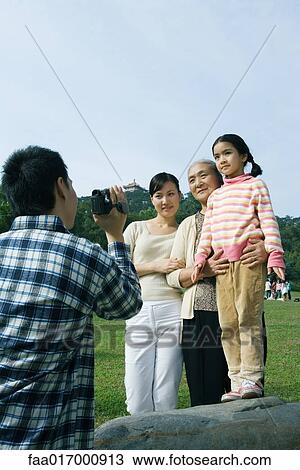 Man filming family in park with video camera View Large Photo Image Stock Image - Man filming family in park with video camera. Fotosearch