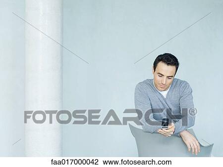 Man looking at cell phone View Large Photo Image Stock Image - Man looking at cell phone. Fotosearch
