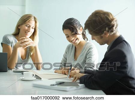 Mature man sitting at table with teenage girl and young female professional, signing document View Large Photo Image Stock Image - Mature man sitting at table with teenage girl and young female professional, signing document. Fotosearch