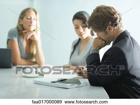Mature man sitting at table with teenage girl and young female professional, reading document View Large Photo Image Stock Photo - Mature man sitting at table with teenage girl and young female professional, reading document. Fotosearch