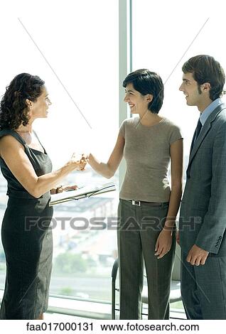 Stock Image - Mature professional woman shaking hands with female client. Fotosearch