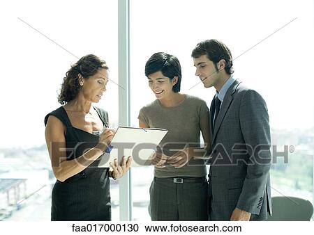 Mature professional woman showing file to young professional couple View Large Photo Image Stock Image - Mature professional woman showing file to young professional couple. Fotosearch