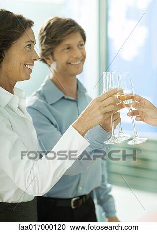Stock Image - Mature professionals toasting with glasses of champagne. Fotosearch