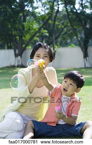 Mother and son making bubbles View Large Photo Image Stock Image - Mother and son making bubbles. Fotosearch